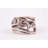 A white gold and diamond swept band ring, the waved mount set with seven small diamonds,