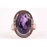 A 14ct white gold, diamond, and amethyst ring, set with a mixed oval-cut amethyst, within plain