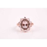 A rose gold, diamond, and morganite cluster ring, set with a mixed oval-cut morganite of