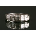 A white metal and diamond band ring, set with graduated rows of mixed baguette-cut diamonds,