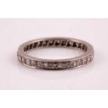 A diamond eternity ring, set with round-cut diamonds, set in unmarked white metal (likely white gold