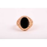 A gentleman's 14ct yellow gold and onyx ring, the textured mount inset with a black oval onyx