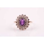 A 9ct yellow gold, amethyst, and white paste stone cluster ring, set with a mixed oval-cut
