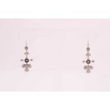 A pair of diamond drop earrings, the unusual mount with a harebell-shape above a horizontal line