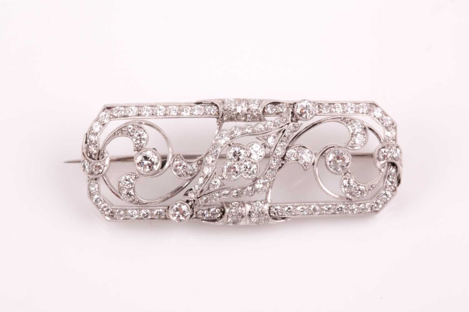 A platinum and diamond plaque brooch, of foliate design, inset with round-cut diamonds, total