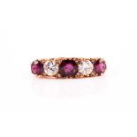 A five stone half hoop ruby and diamond ring; the round brilliant cut diamonds and circular cut