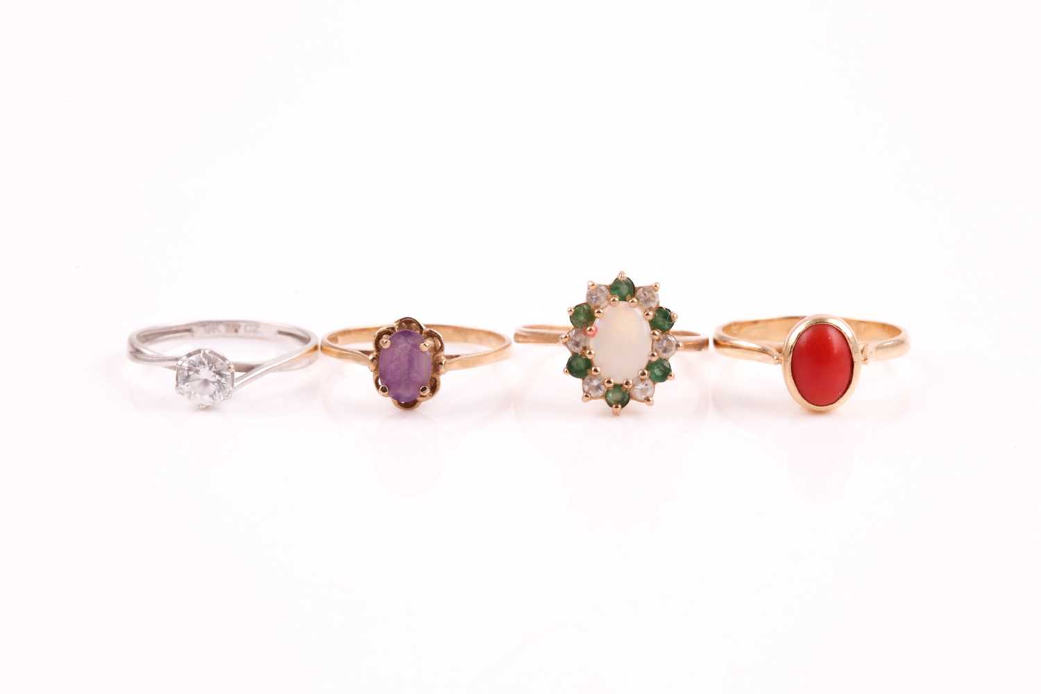 A single stone coral ring, the yellow metal mount marked '585'; a single stone amethyst ring, an