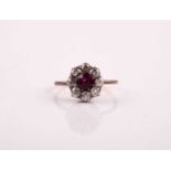 A French ruby and diamond cluster ring, the circular cut ruby claw mounted within a border of old