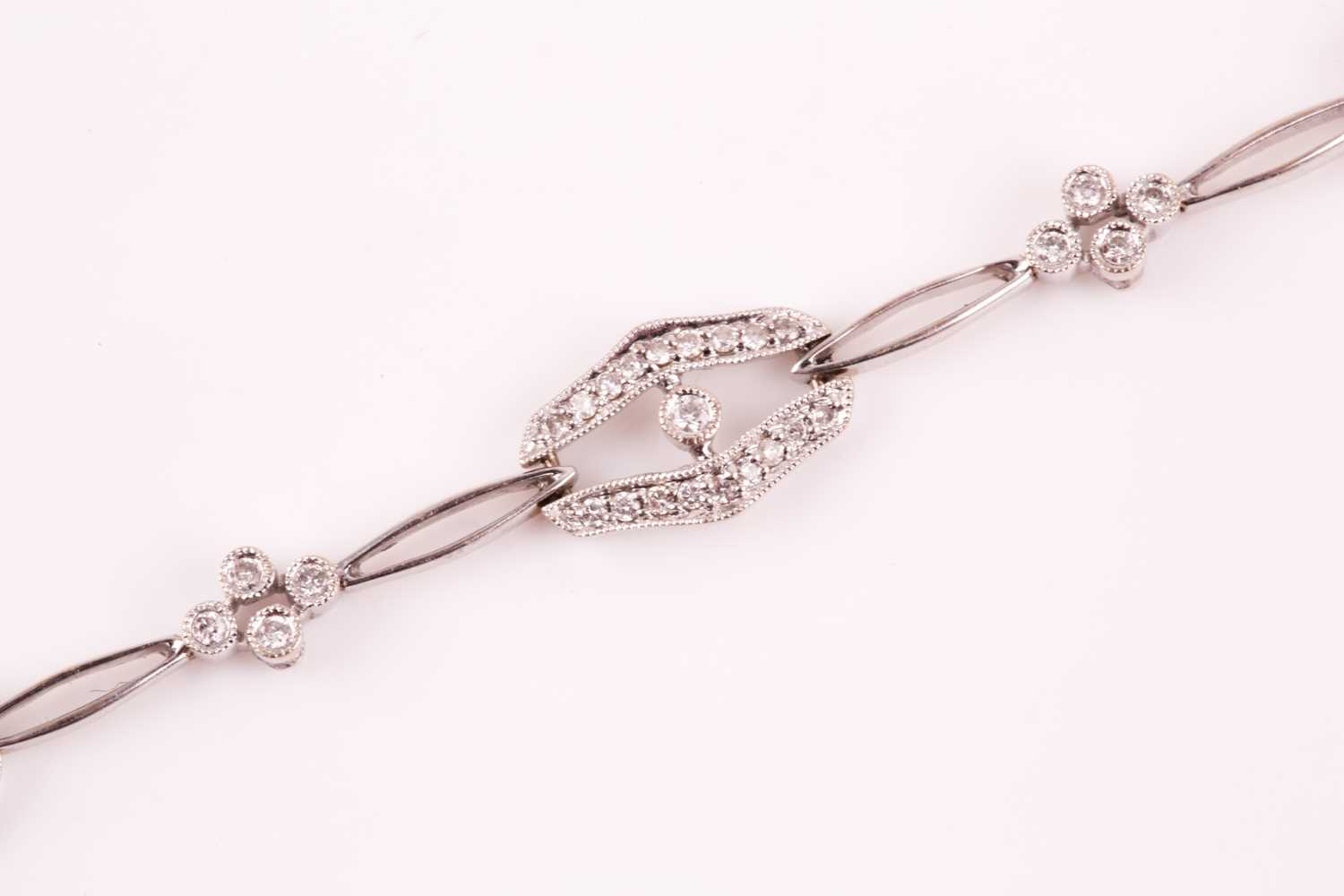 A diamond bracelet; of alternating diamond set openwork lozenge and four stone diamond clusters - Image 6 of 14