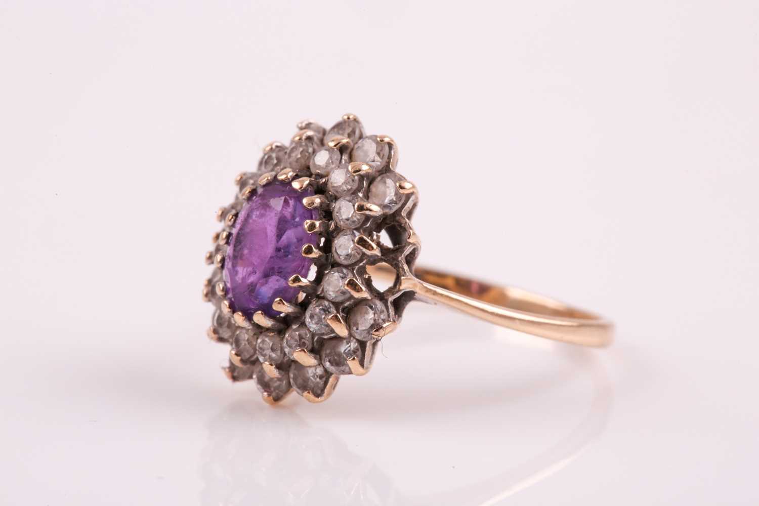 A 9ct yellow gold, amethyst, and white paste stone cluster ring, set with a mixed oval-cut - Image 6 of 6