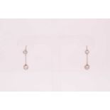 A pair of diamond drop earrings, each collet-set with a round-cut diamond above an old round-cut