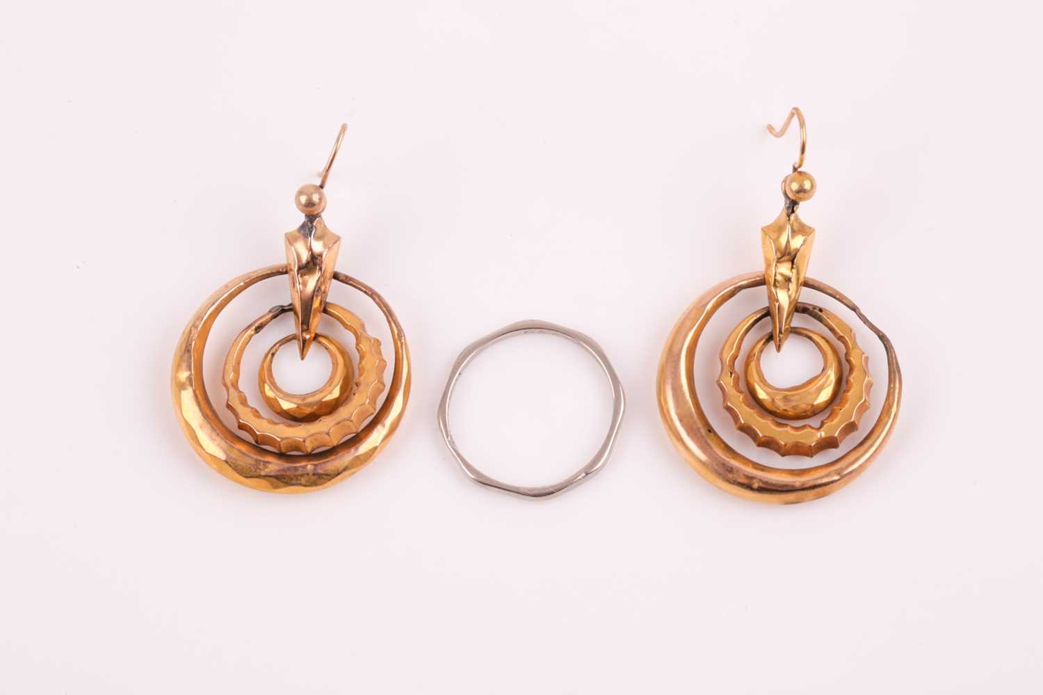 A pair of Victorian yellow metal triple hoop earrings, with three articulated hoops suspended from a