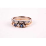 An 18ct yellow gold, diamond, and sapphire ring, set with three round-cut diamonds, largest