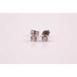 A pair of diamond stud earrings; the round brilliant cut diamonds in simple four claw mounts.