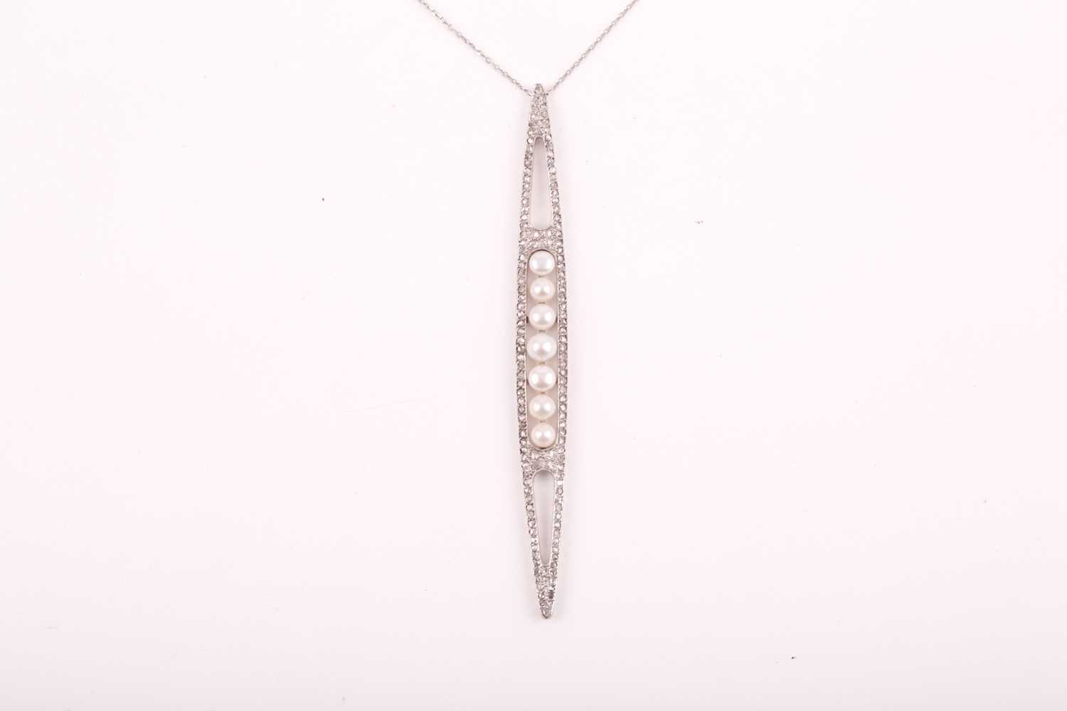 An unusual converted Edwardian diamond and pearl pendant, the elongated openwork mount centred