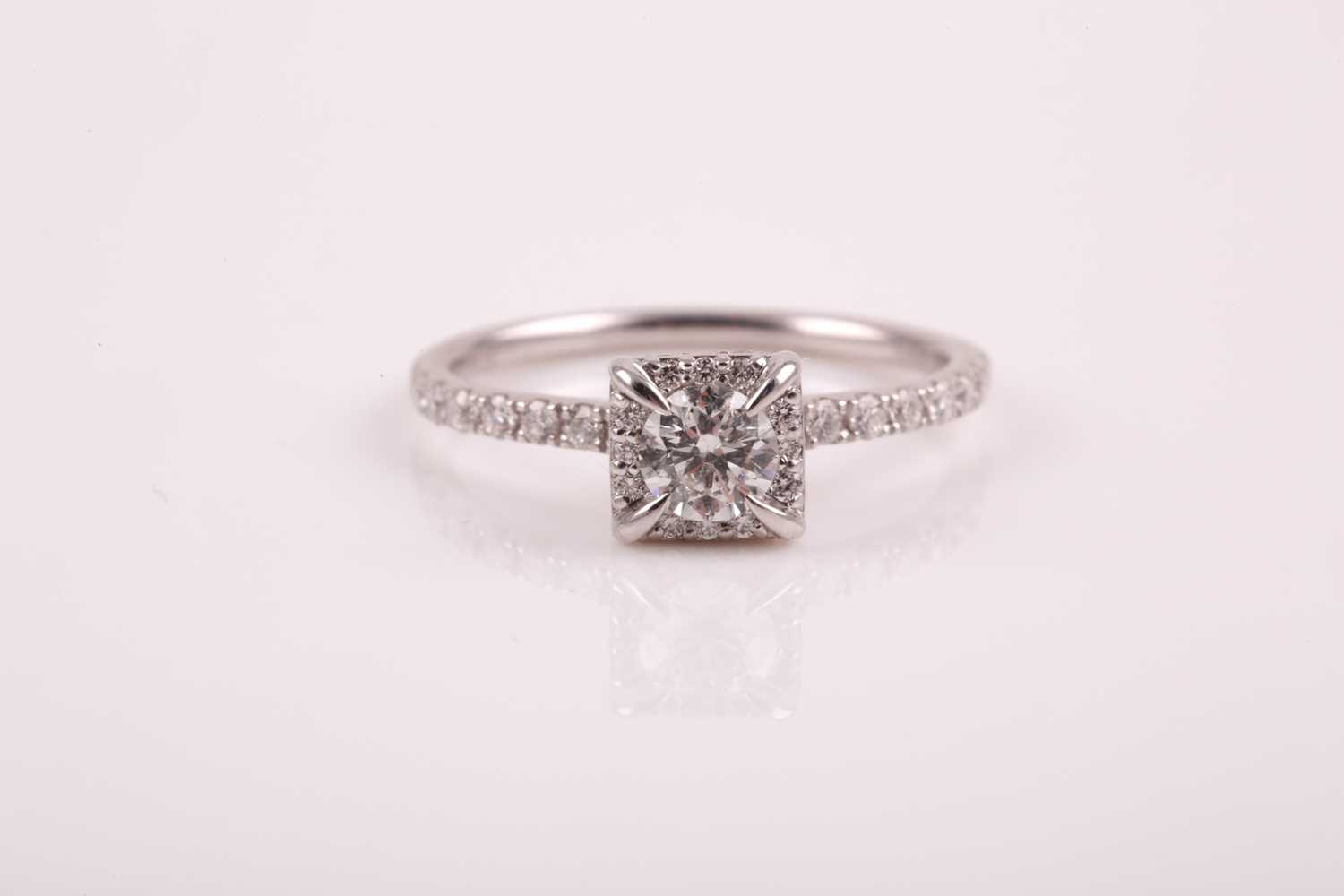 A 14ct white gold and diamond cluster ring, set with a round brilliant-cut diamond of