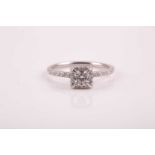 A 14ct white gold and diamond cluster ring, set with a round brilliant-cut diamond of
