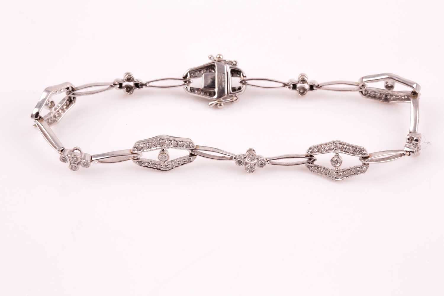 A diamond bracelet; of alternating diamond set openwork lozenge and four stone diamond clusters - Image 5 of 14