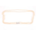 A double strand pearl necklace, set with a diamond clasp, the lozenge-shaped clasp set with nine old