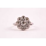 A platinum and diamond daisy cluster ring, set with round brilliant-cut diamonds of approximately