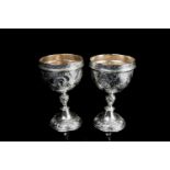 A pair of 19th-century Continental silver stacking goblets with repousse strapwork and satyrs