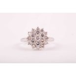 A diamond cluster ring, the tired three row cluster set with 19 round brilliant cut diamonds, in