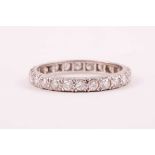 A diamond eternity ring; the mixed round brilliant-cut diamonds claw mounted within a slightly