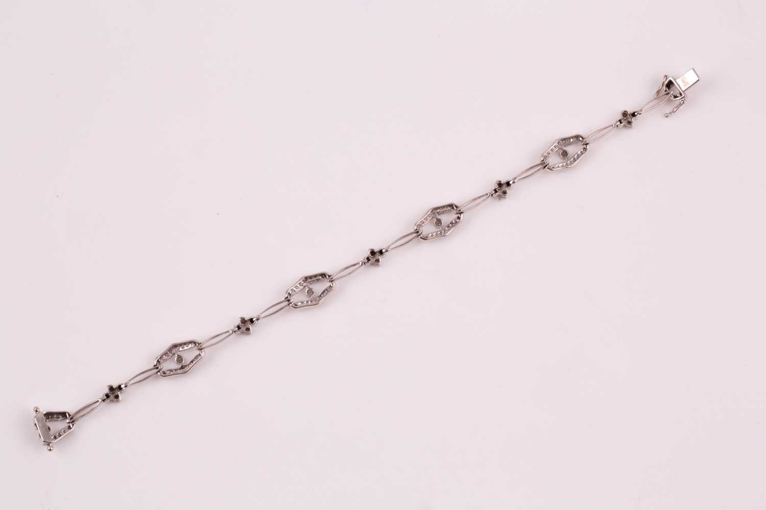 A diamond bracelet; of alternating diamond set openwork lozenge and four stone diamond clusters - Image 4 of 14