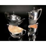 A matched four piece silver tea set, William Hutton & Sons Ltd, London 1912 and Sheffield 1923/24,