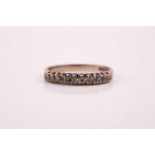 An 18ct white gold and diamond half hoop eternity ring; the single cut diamonds in claw mounts to