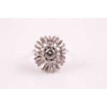 A diamond cluster ring, the central brilliant cut diamond in raised eight claw mount within an inner