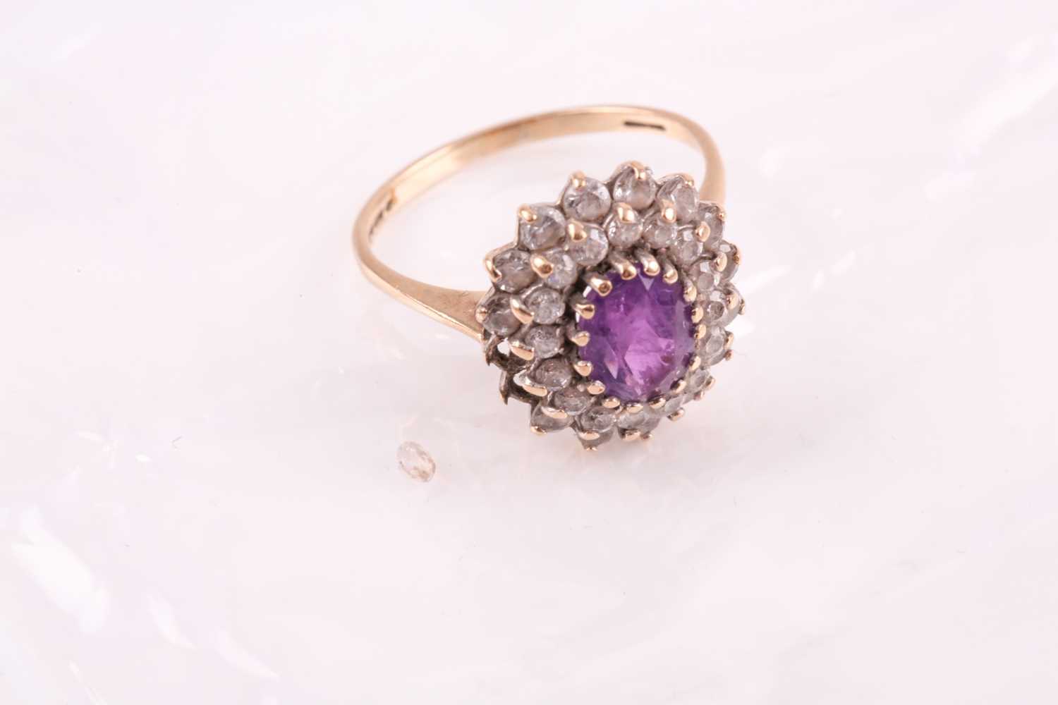 A 9ct yellow gold, amethyst, and white paste stone cluster ring, set with a mixed oval-cut - Image 2 of 6