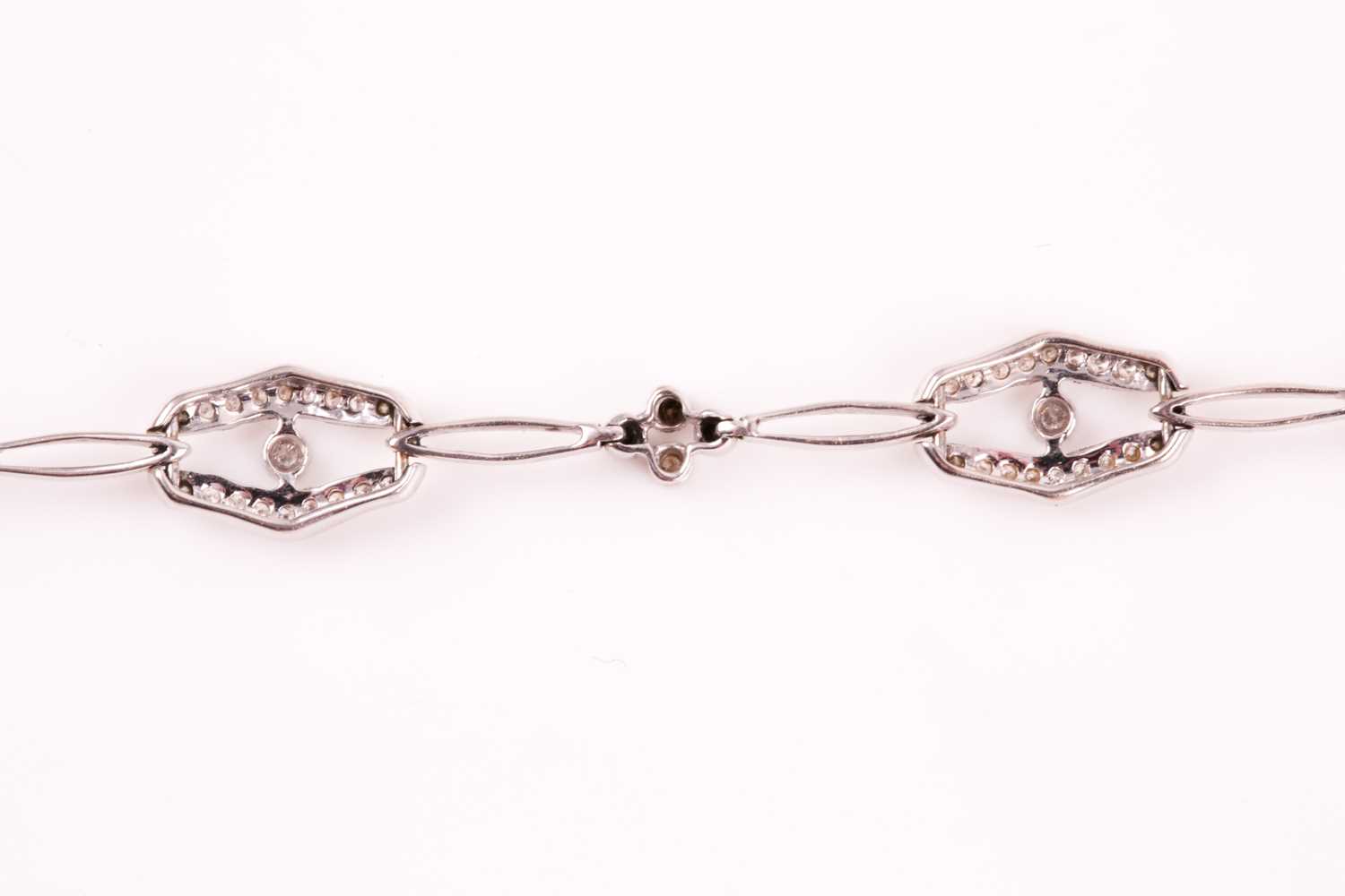 A diamond bracelet; of alternating diamond set openwork lozenge and four stone diamond clusters - Image 3 of 14