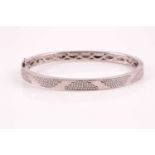 An 18ct white gold and diamond bracelet; the polished bangle with pave set round brilliant cut