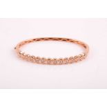 An 18ct rose gold and diamond bangle, the bracelet collet-set with round brilliant-cut diamonds of