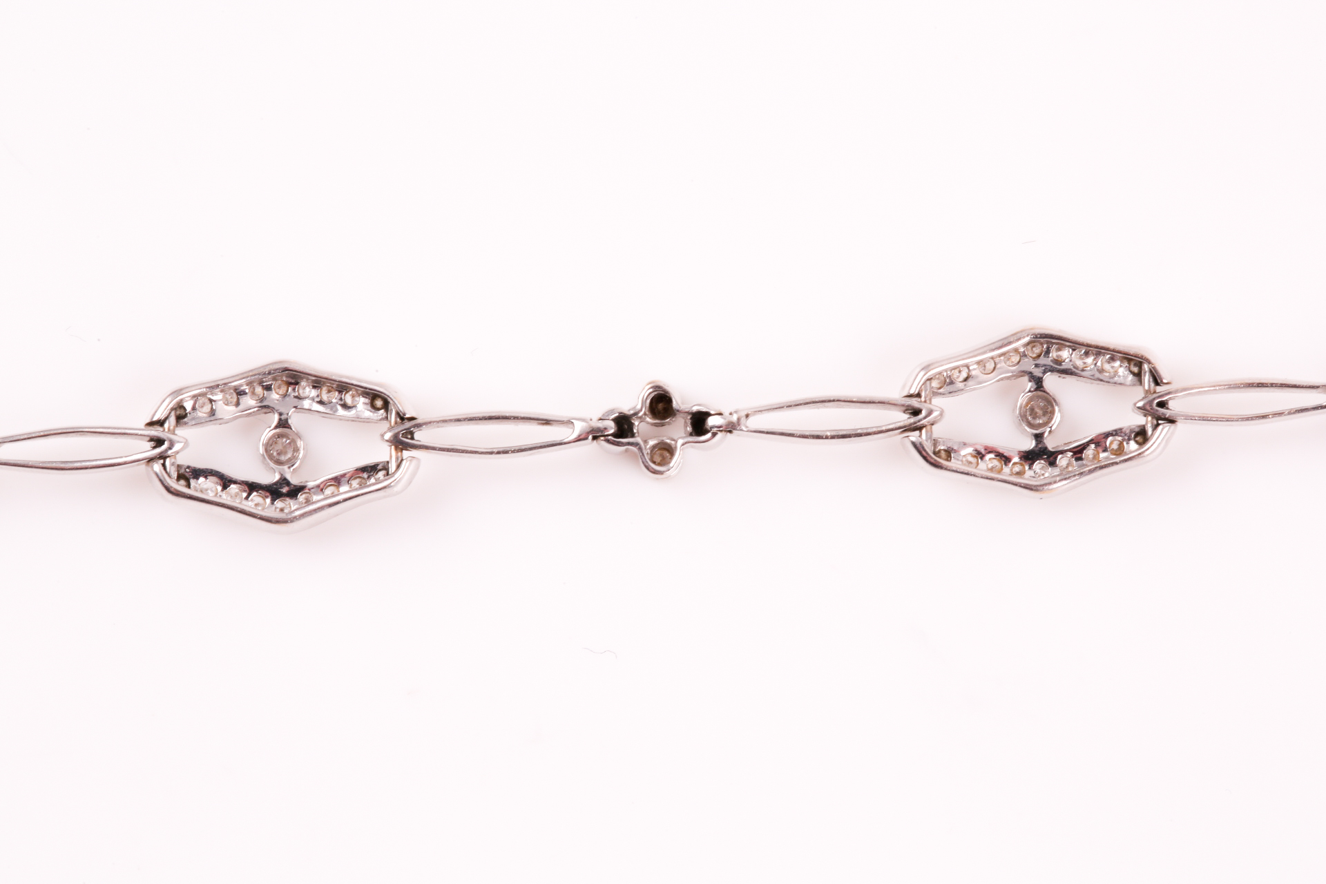 A diamond bracelet; of alternating diamond set openwork lozenge and four stone diamond clusters - Image 12 of 14