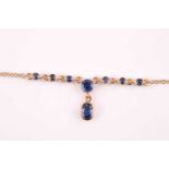 A 9ct yellow gold and sapphire drop pendant necklace, set with round and mixed-oval cut sapphires,