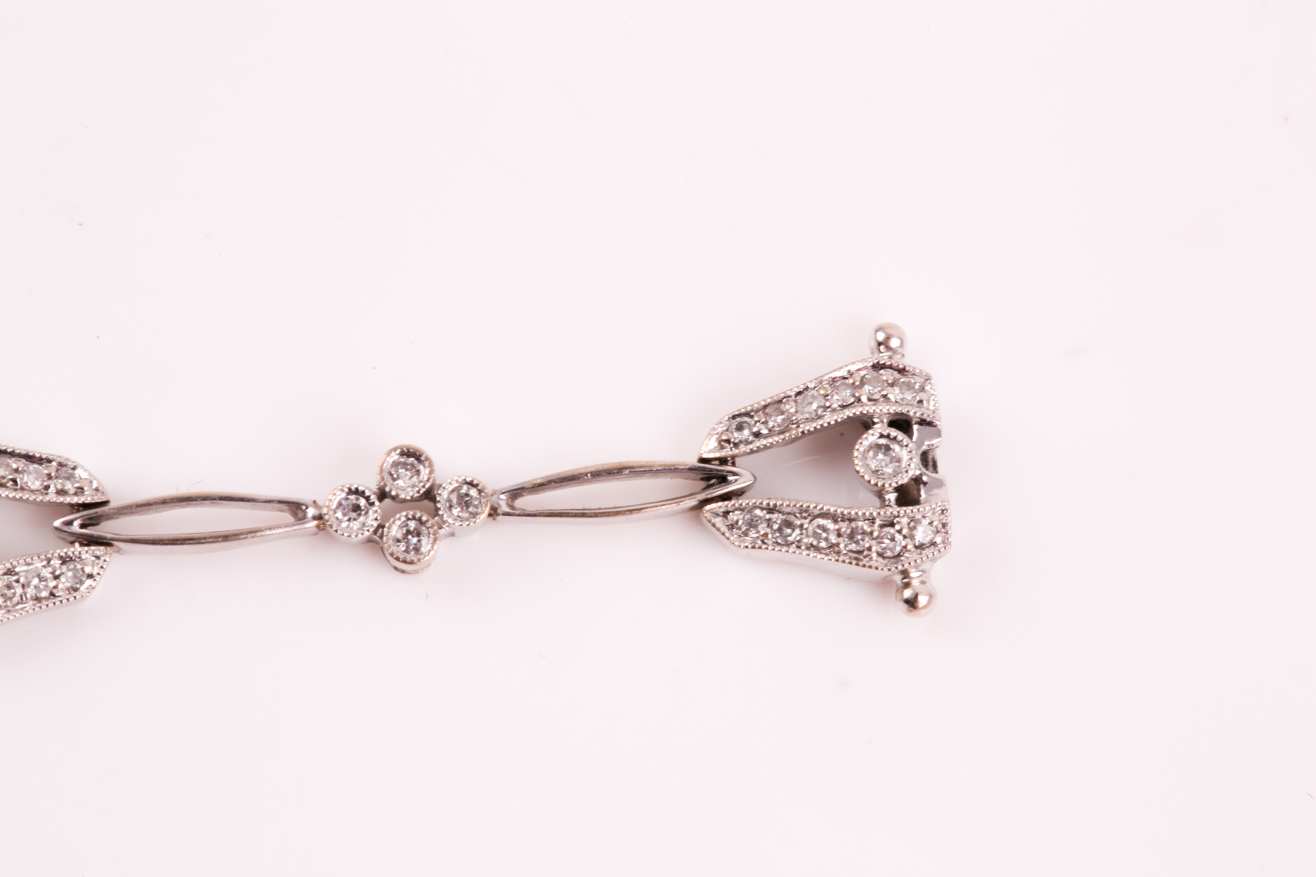A diamond bracelet; of alternating diamond set openwork lozenge and four stone diamond clusters - Image 11 of 14