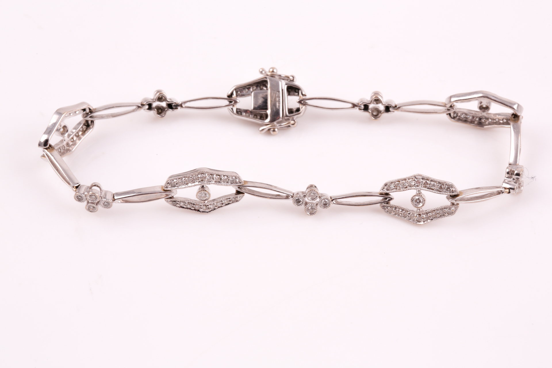 A diamond bracelet; of alternating diamond set openwork lozenge and four stone diamond clusters - Image 14 of 14