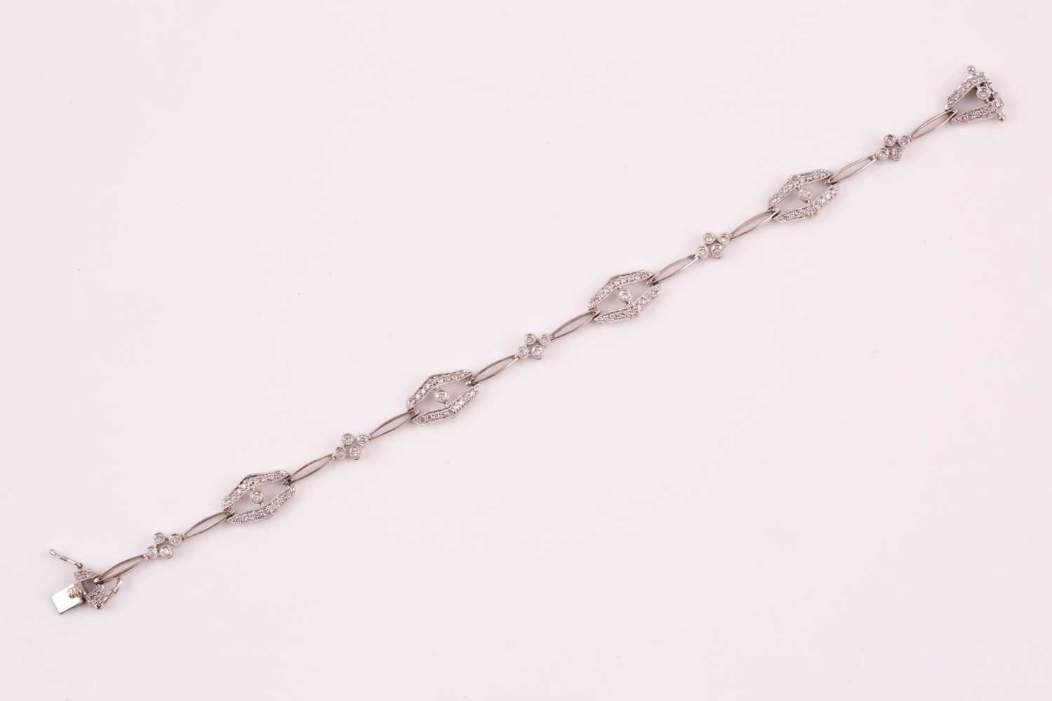 A diamond bracelet; of alternating diamond set openwork lozenge and four stone diamond clusters