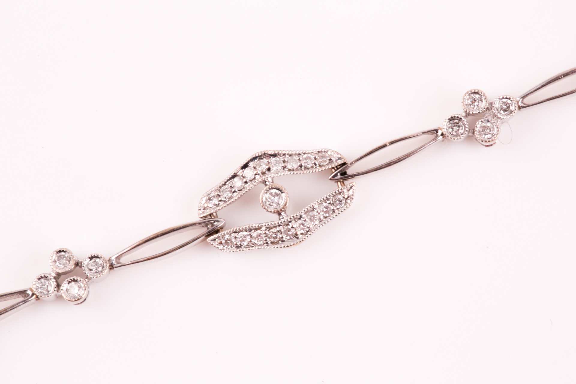 A diamond bracelet; of alternating diamond set openwork lozenge and four stone diamond clusters - Image 9 of 14