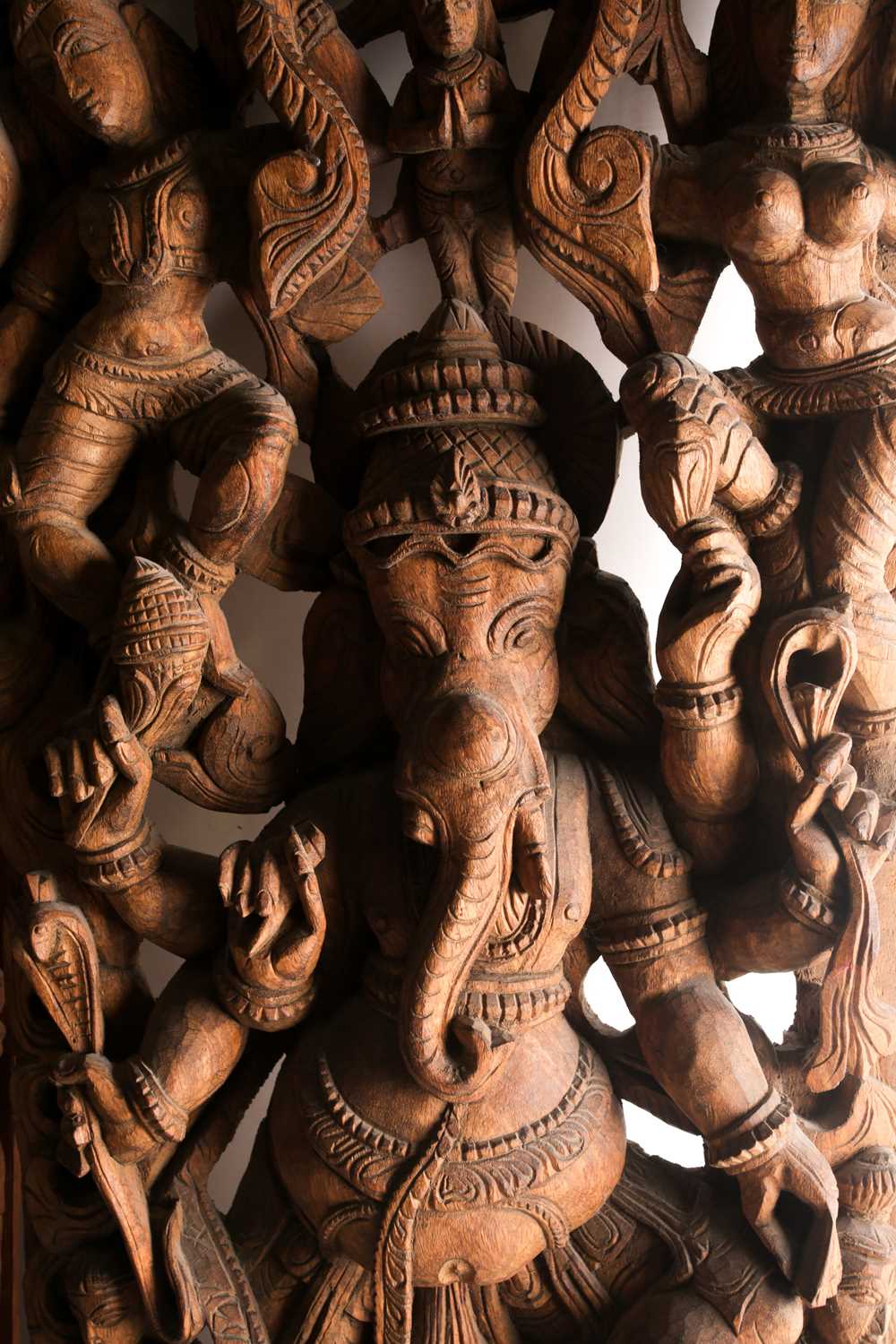 An Indian teak wood arched architectural panel, carved and pierced with Lord Ganesh and attendants - Image 5 of 8