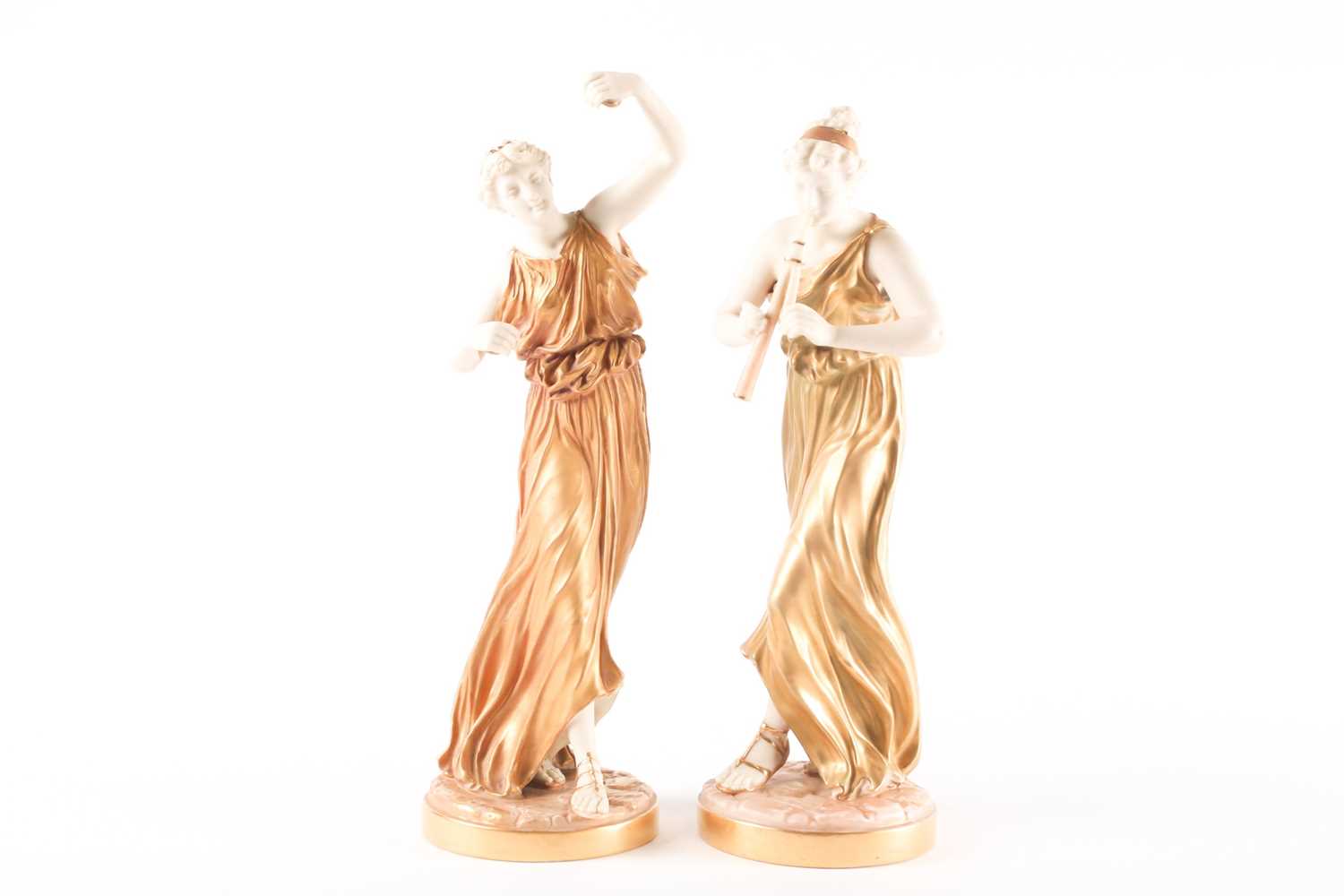 A pair of Royal Worcester blush ivory figures of Grecian musicians, modelled by James Hadley, one