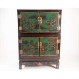 An early 20th-century Chinese, black and green lacquered two-section cabinet fitted a pair of