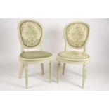 A pair of Edwardian salon/dining chairs painted in green with floral upholstery, with plaques