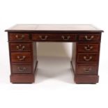 A late 19th century pedestal desk, with tooled leather writing surface above a series of nine