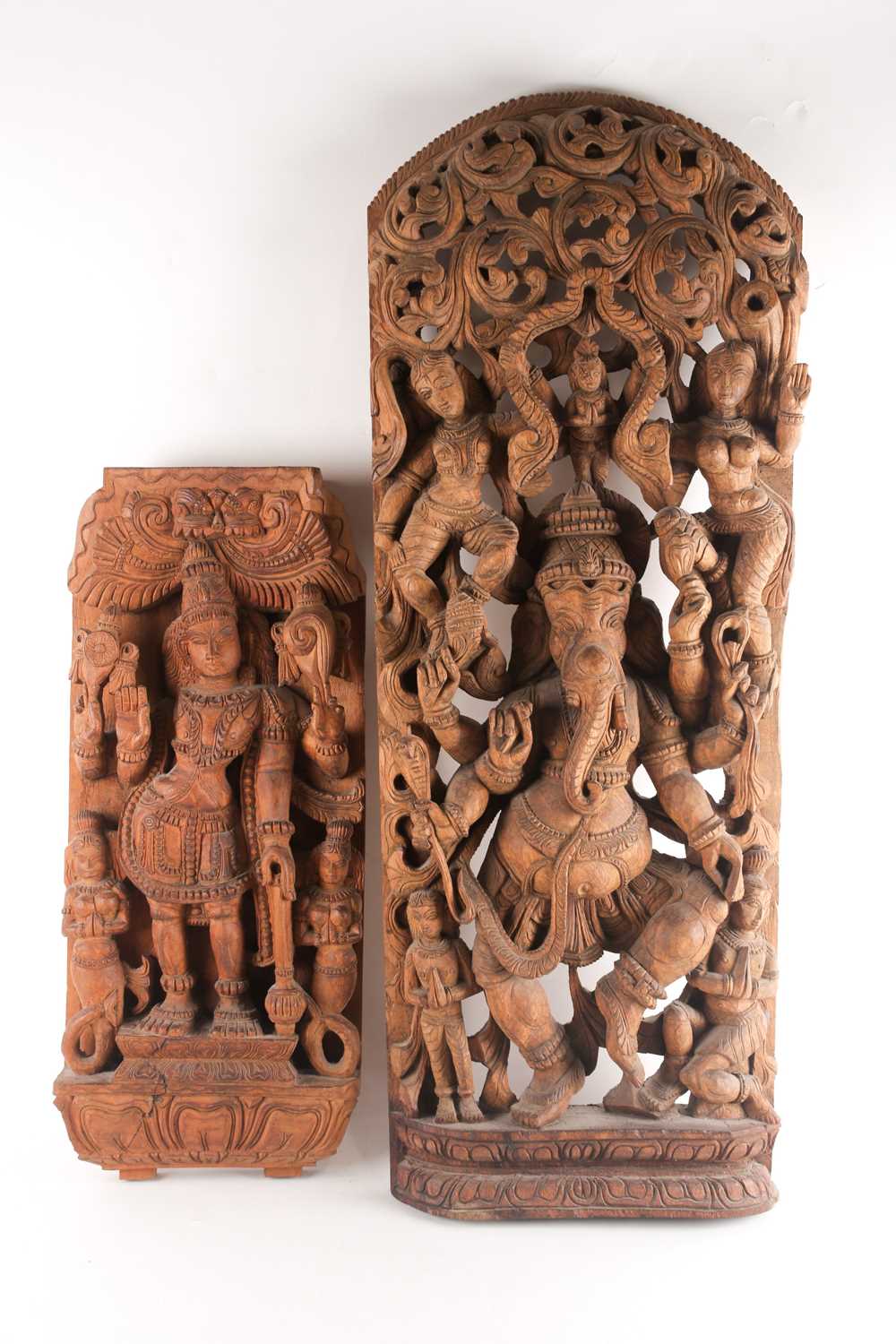 An Indian teak wood arched architectural panel, carved and pierced with Lord Ganesh and attendants