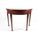 A George III rosewood crossbanded mahogany demi lune fold over card table with paterae carved and