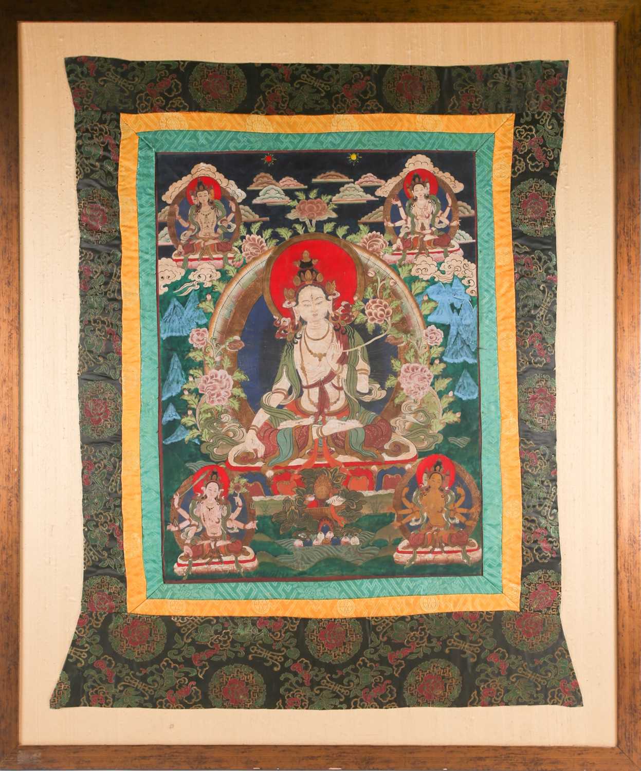 A Tibetan thangka painted on fabric depicting the seated white Tara with her hands in the varada