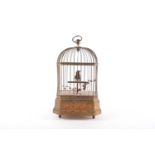 An early 20th century singing bird automaton, in a gilded cage, the base with moulded foliate